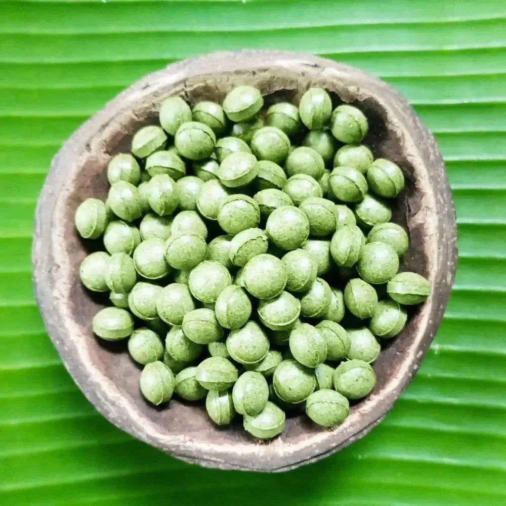 Billes de Moringa dans un bol en bois sur une feuille verte, super aliment riche en nutriments et antioxydants.