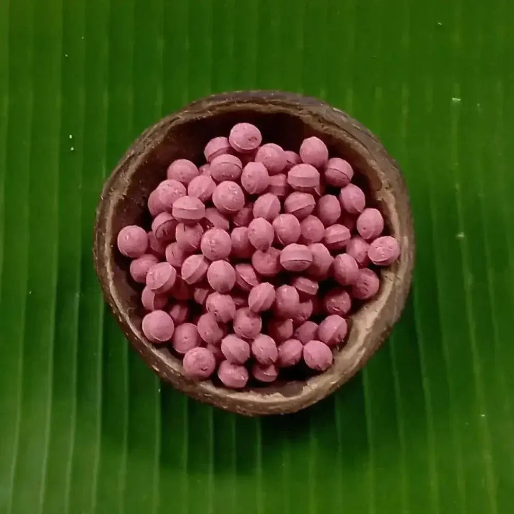 La Rosella natural supplement tablets in a coconut bowl on a green leaf background.